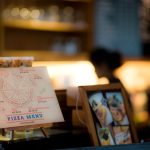 Close-up of a printed pizza menu in a warmly lit restaurant