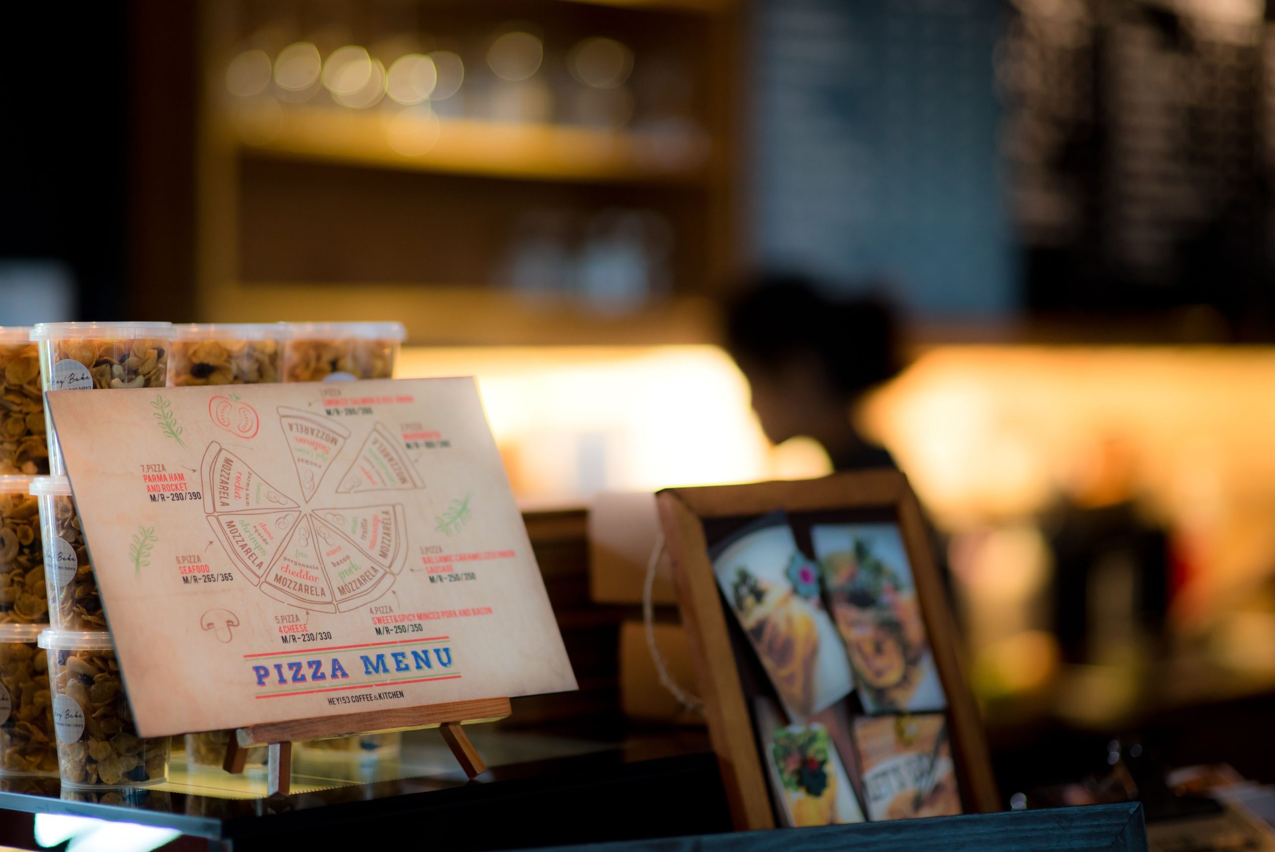 Close-up of a printed pizza menu in a warmly lit restaurant